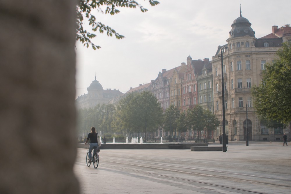 A cyclist riding past colourful historic townhouses on a city street