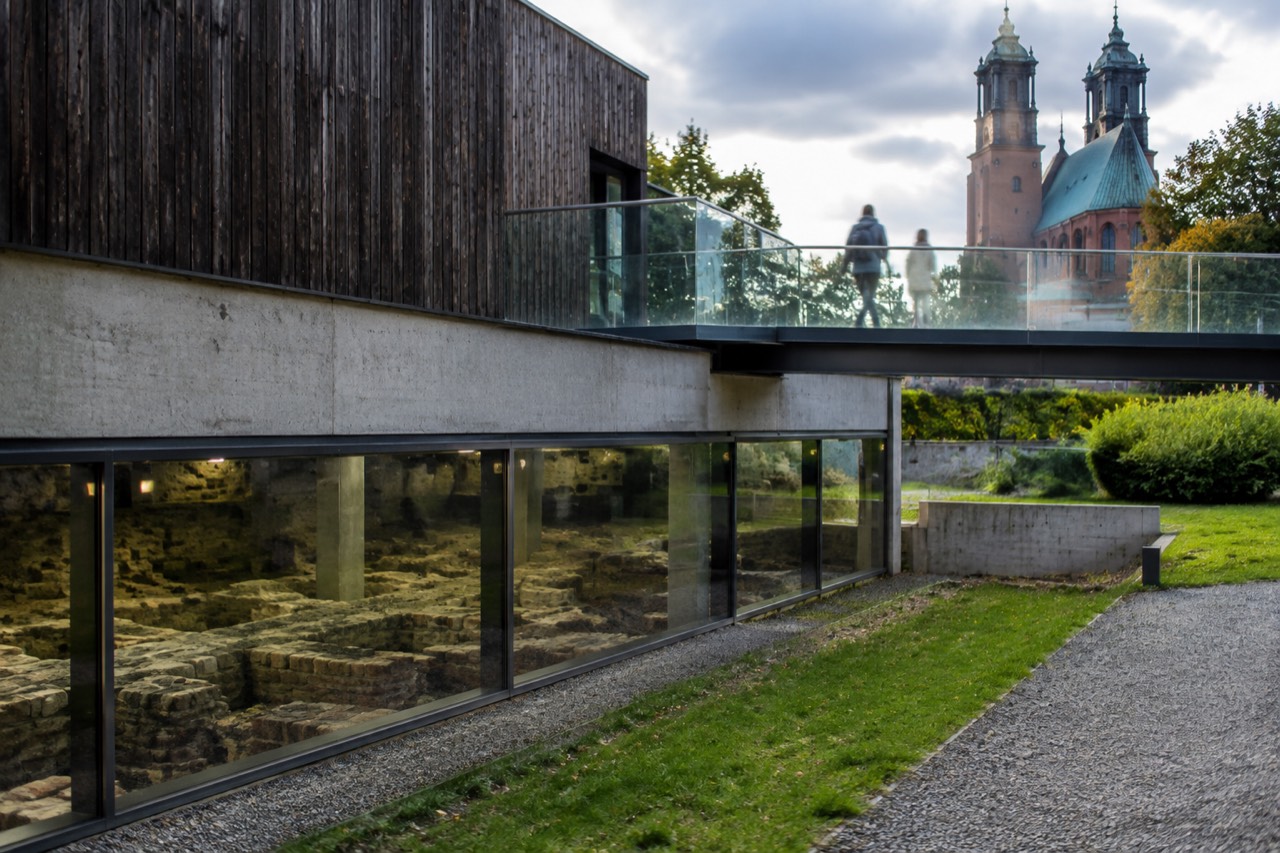 Glass walkway above an exposed archaeological excavation inside a modern exhibition hall