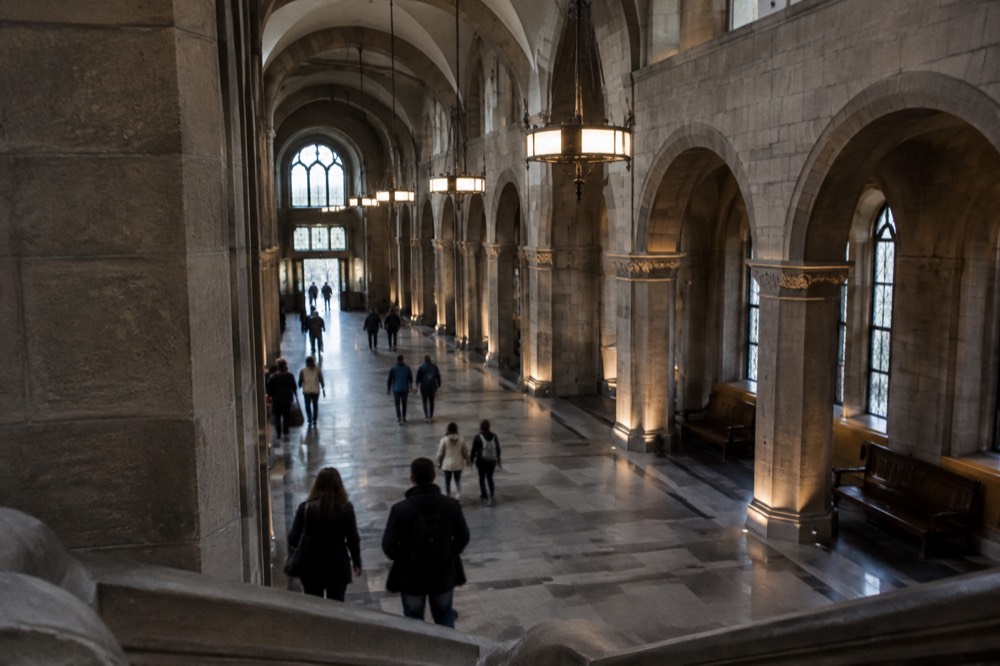 Visitors walking through a grand arcade hall inside the Imperial Castle in Poznan