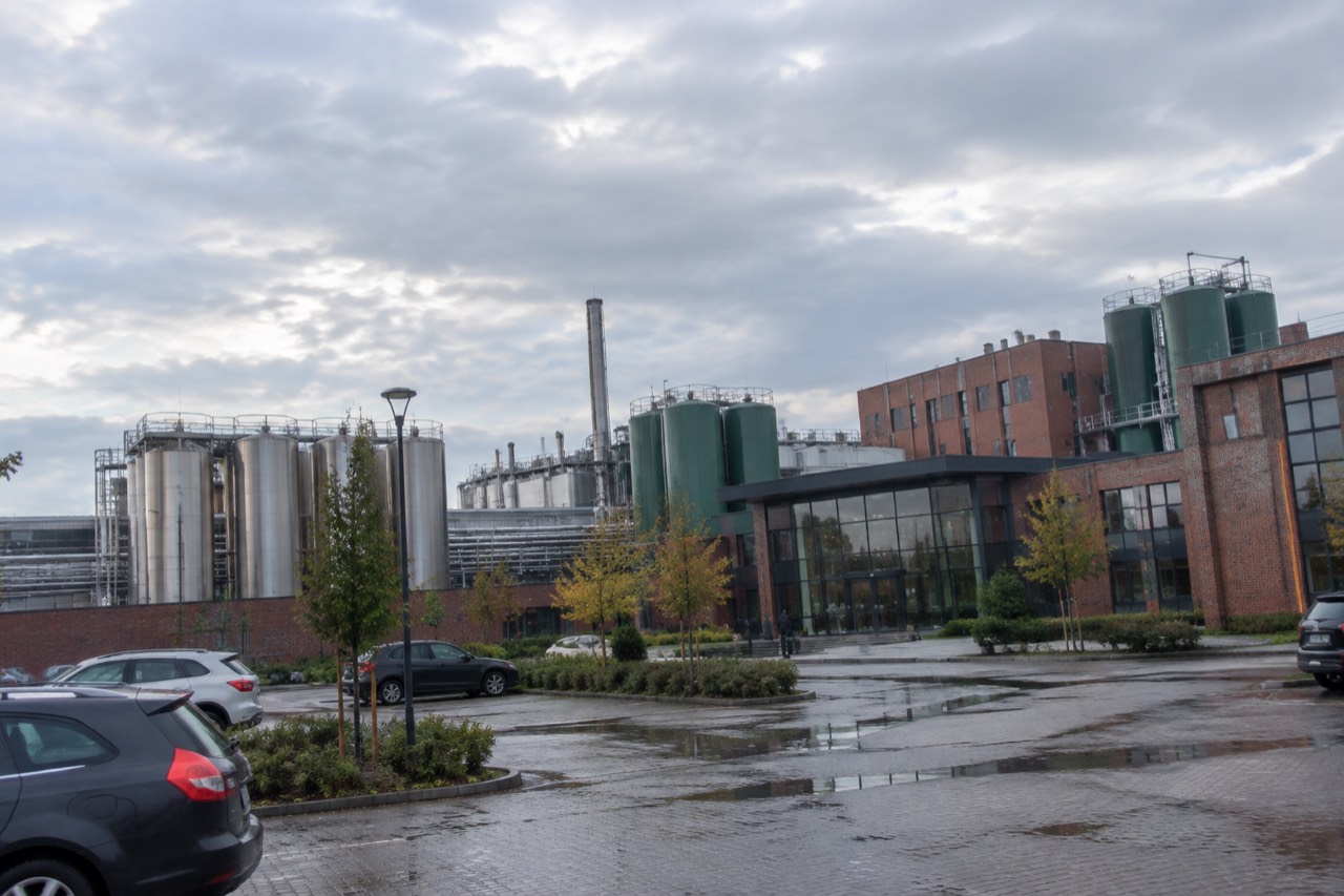 Brewery buildings and green tanks on the Lech plant site in Poznan under a wide sky