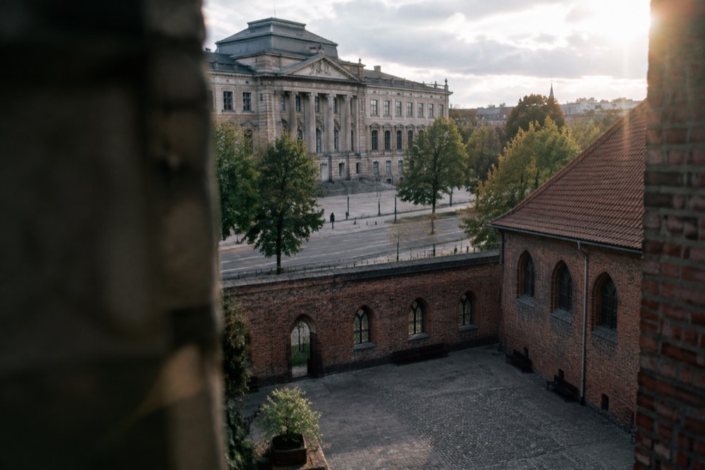 Castle courtyard with brick walls and arched windows seen from above