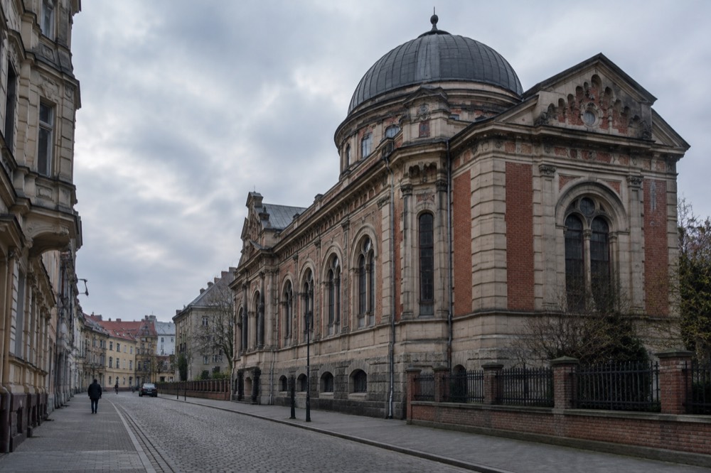 Ornate brick and stone detailing on the facade of a large nineteenth-century style building in Poznan