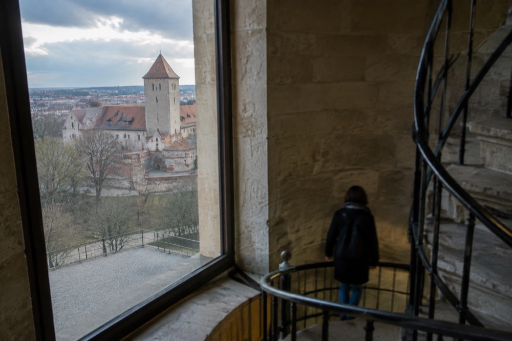 A stone spiral staircase with iron railings inside a castle museum