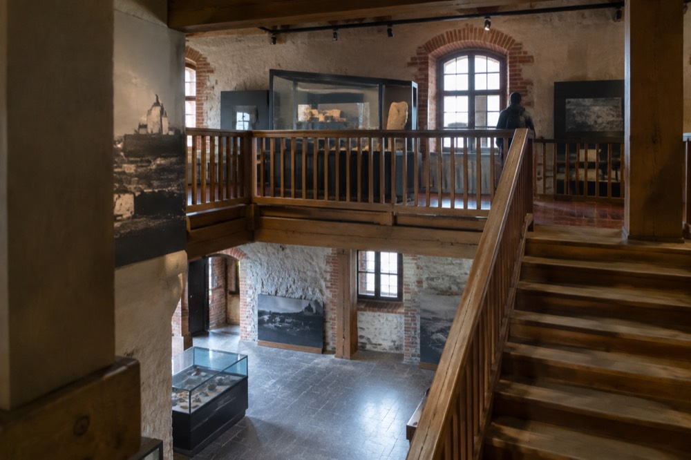 A wooden staircase and mezzanine inside a converted castle interior with displays