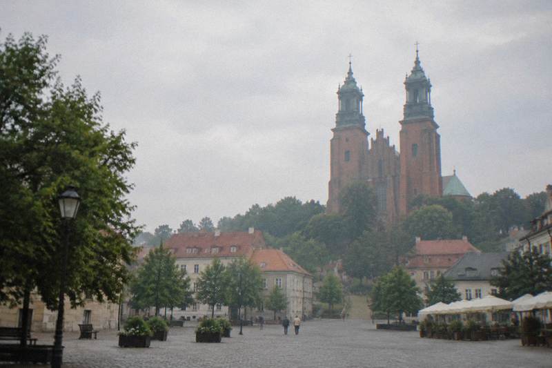 The brick Gothic cathedral and its twin towers rising above the low rooftops of Gniezno